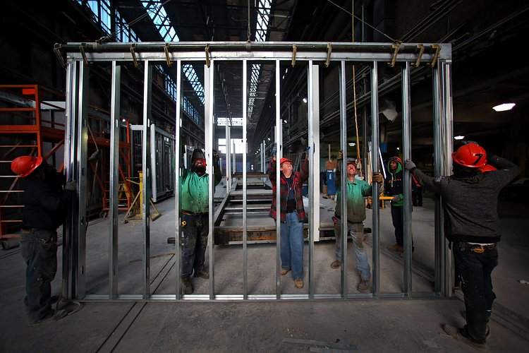 The framing of an interior wall being lifted into place.