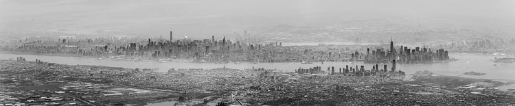 Manhattan Haze | Panorama taken from a flight out of Newark on a hazy day.  Canon 6D with a Canon 70-200mm f/2.8L (mark 1, non-IS). Stitched together with Microsoft ICE.

The original color image had a heavy, almost monochrome, blue cast.  Do you think I should have left the color in?