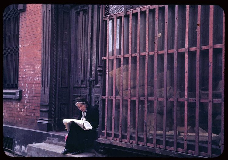 This woman enjoys her Sunday newspaper on a stoop in the Lower East Side.