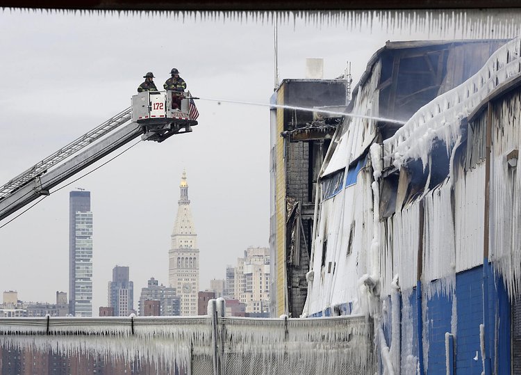 Firefighters continued pouring water on the remains of a 7-alarm fire in a warehouse on the Williamsburg waterfront