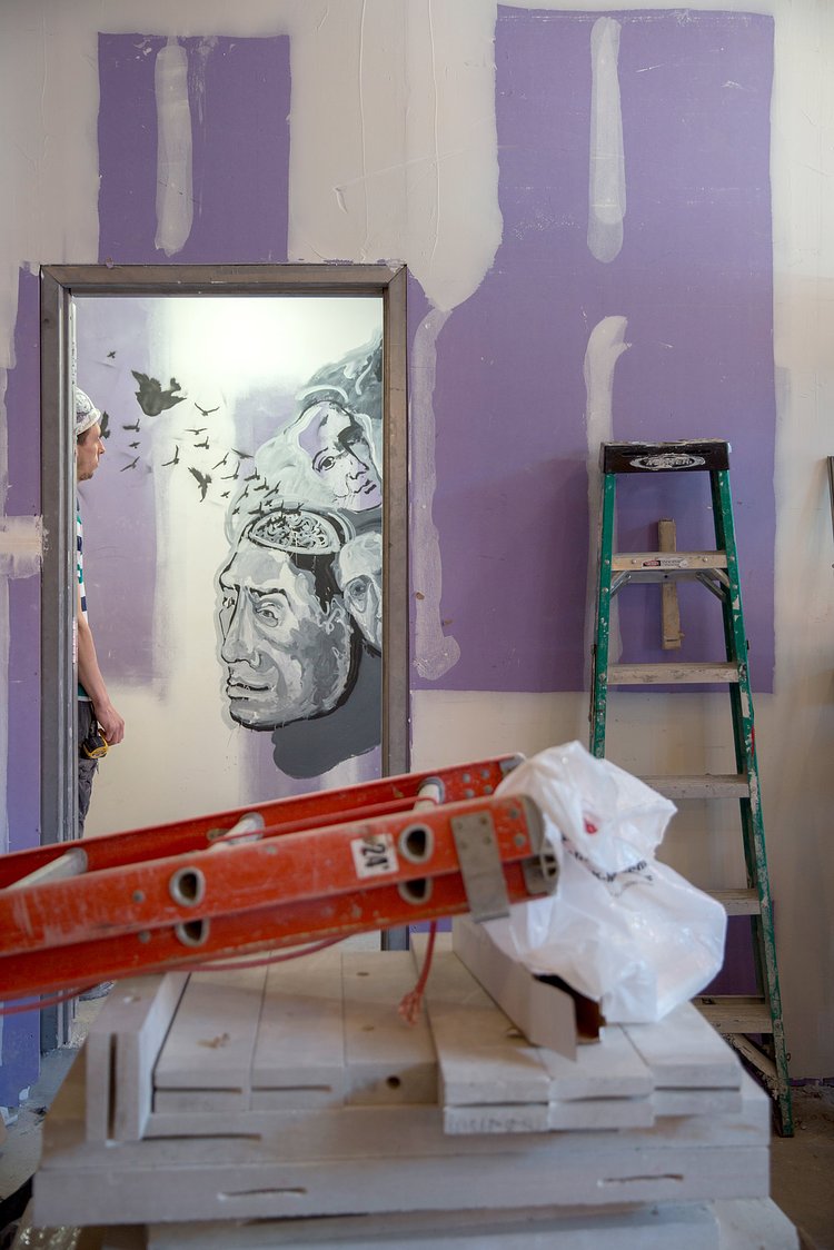 Here the artist regards one of his murals in a stairwell at the construction site.