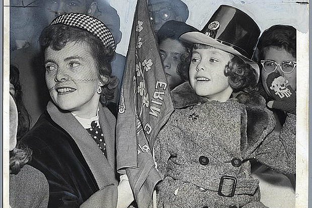 A mother and daughter pair cheer on St. Patrick's Day revelers near 49th Street in 1953.