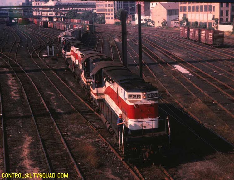 This is a 1982 photo of a long inbound freight LIRR freight train arriving in ‘Yard A’ at sunnyside, as seen from the Honeywell Avenue bridge. You can see the 7 train and CN West factory in the distance. The train is being lead by 4 “C420” freight locomotives built by the American Locomotive Company, located in upstate NY – they’re still painted in a red white & blue paint job applied to many LIRR locomotives in celebration of the 1976 US bicentennial.