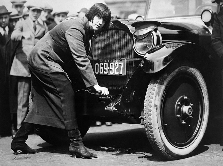 Miss Maude Odell, one of the first women taxi drivers in New York. She is cranking car (Hub Taxicab Corporation), 1923.