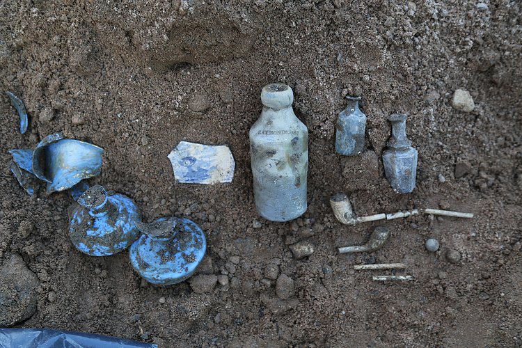 Broken pipes and plate fragments were among the finds in the old outhouse well.