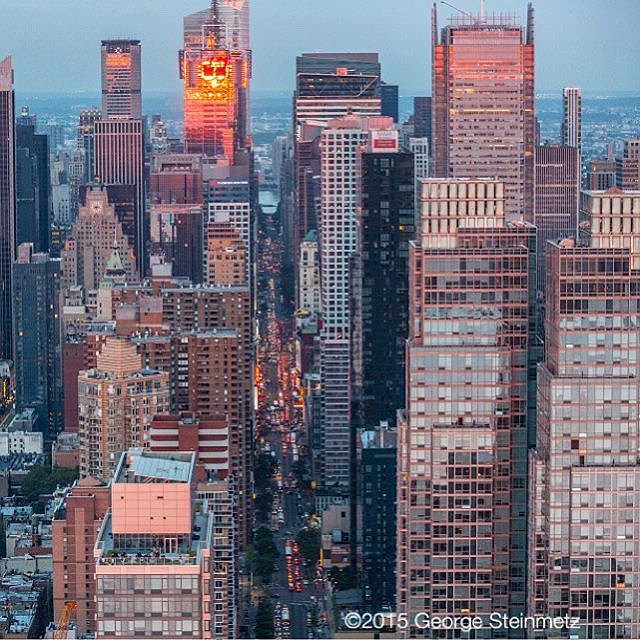 Photograph by George Steinmetz @geosteinmetz / @thephotosociety  Sunset reflects off the H&M building in this view looking east on 42nd St. towards Midtown in New York City.