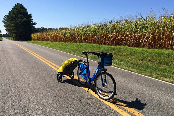 Tanenhaus hauls his travel essentials in a small trailer hitched to the seat post.