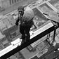 A construction worker on a beam high above the building at Wall Street, New York City, 1930.