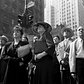 People in Times Square watch the news ticker on the New York Times building