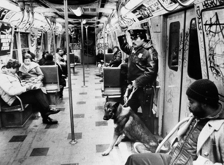 1980's: Transit police officer Emilio Mesa and police dog Blitz ride a graffiti covered subway car.
