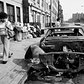 A pedestrian looking at a stripped car in the East Village on Oct. 14, 1979.