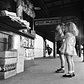 A brother and his sister look up at a newsstand, located on the platform of the New York city subway, as they wait for the train to Coney Island, New York, 1948.