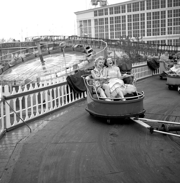 Models from the CBS gameshow, "The Big Payoff," Cindy Robbins and Pat Conway ride The Whip designed and built by W.F. Mangels Company of Coney Island, at Steeplechase Park. Coney Island, Brooklyn, NY.