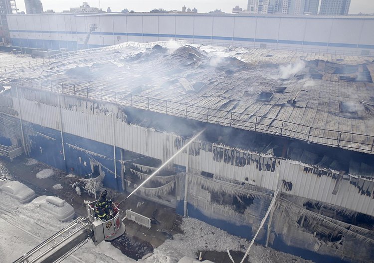 Firefighters continued pouring water on the remains of a 7-alarm fire in a warehouse on the Williamsburg waterfront