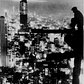 A man sits on a girder above New York City at night, ca. 1935