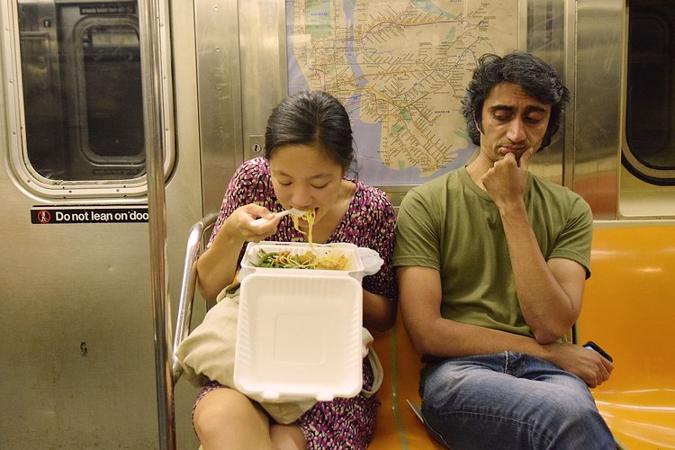 Woman Eating Takeout on Subway While Man Gives Side Eye | You can use this photo for non-commercial purposes if you give credit, under this <a href="https://creativecommons.org/licenses/by-nc/3.0/us/" rel="nofollow">Creative Commons license</a>. For-profit media organizations also may use this, but as editorial content only (as illustrations for stories, for example, but not as advertising). Credit must read: Richard Yeh / WNYC

We'd love to know if you're using this photo - send us an email (jkeefe@wnyc.org)!