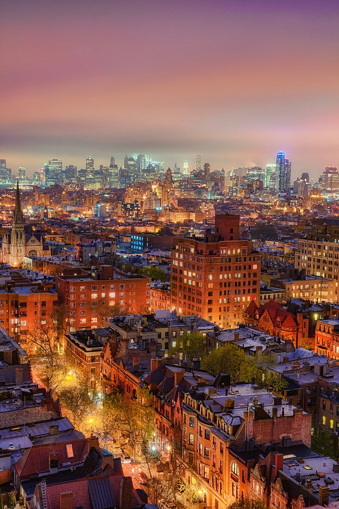 Brooklyn Rooftops | Brooklyn neighborhood in the evening with the Manhattan skyline in the background.  