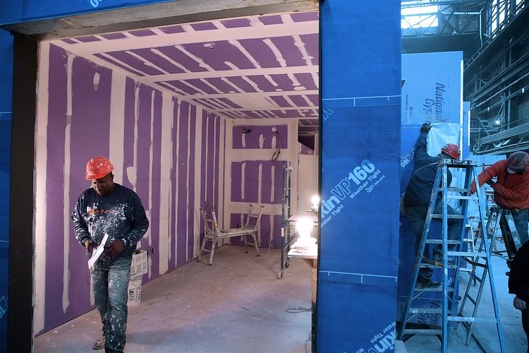 A look into the main living space of an apartment after drywall has been installed.