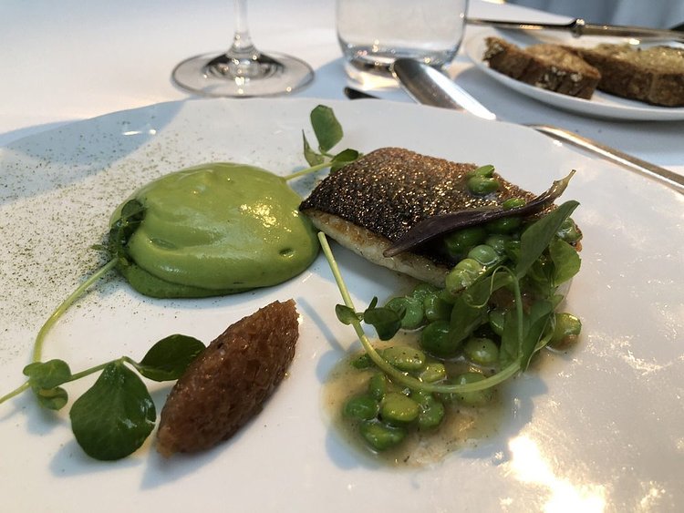 Sautéed sea bass with English peas and caramelized onions.